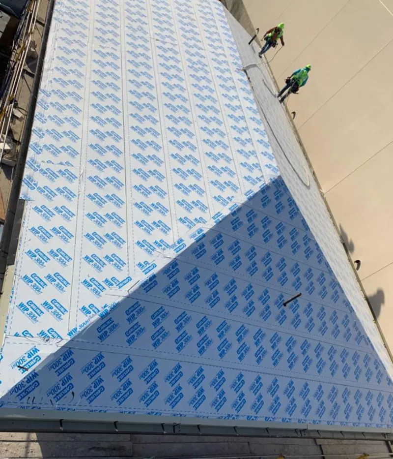 Professional roofers installing underlayment on a metal roof in Chelsea